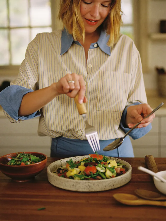 Mujer emplatando una ensalada