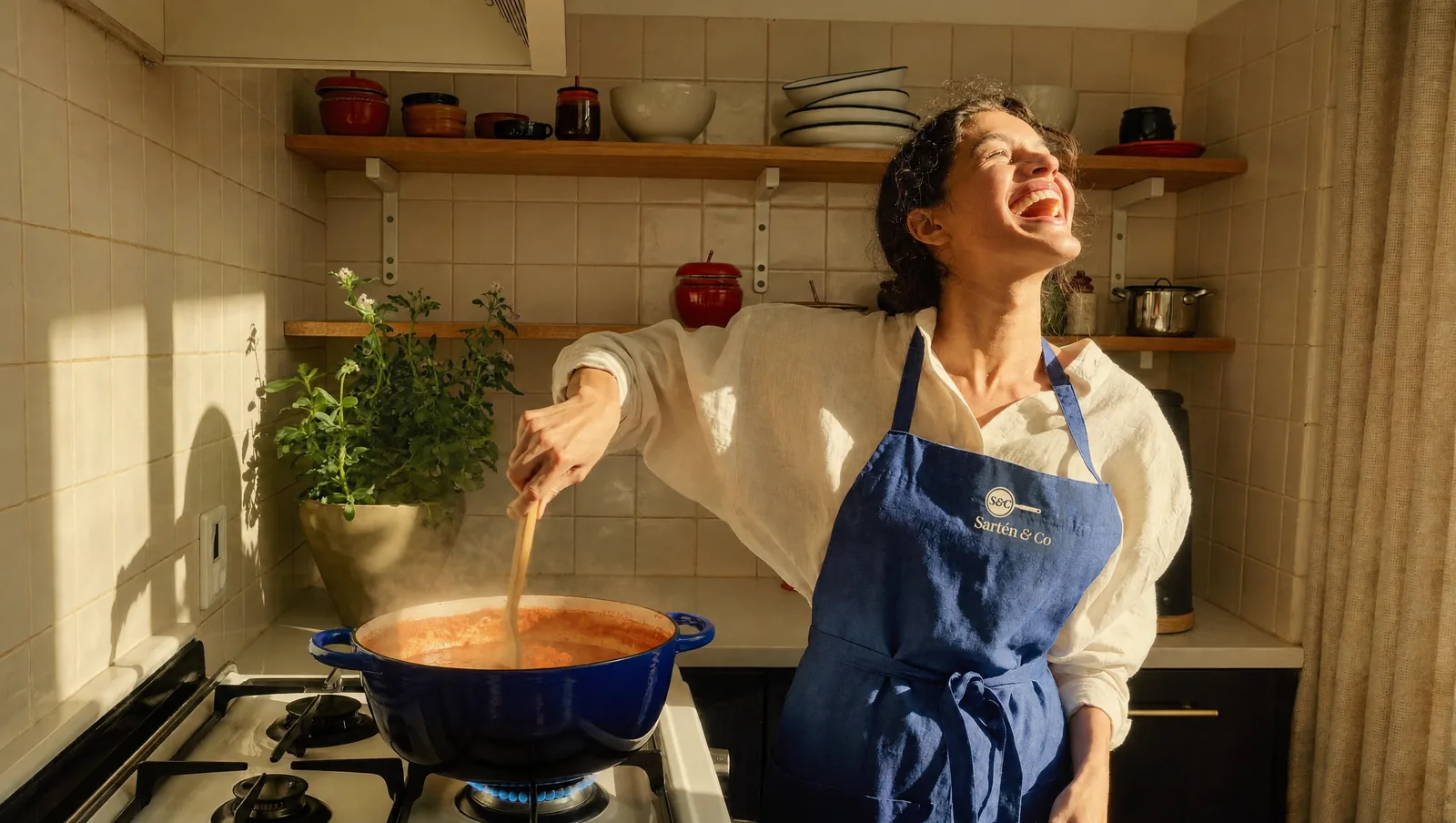 Mujer cocinando un guiso en una cocotte azul en una cocina luminosa